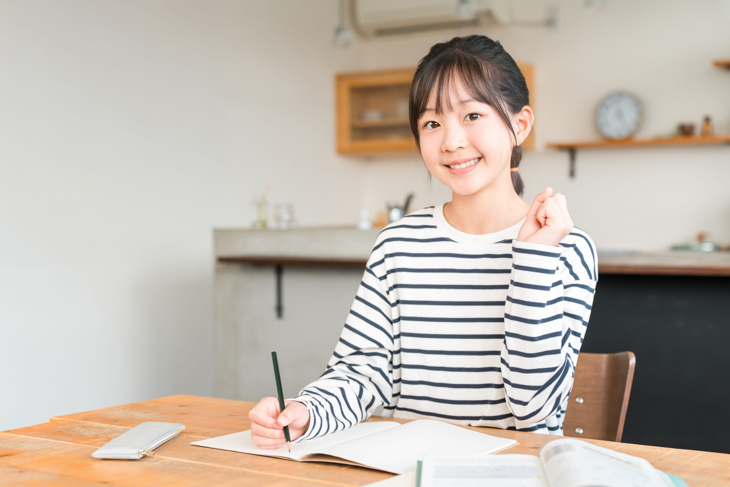 自宅の勉強机で自学ノートを広げて短時間集中で復習に取り組む中学生
