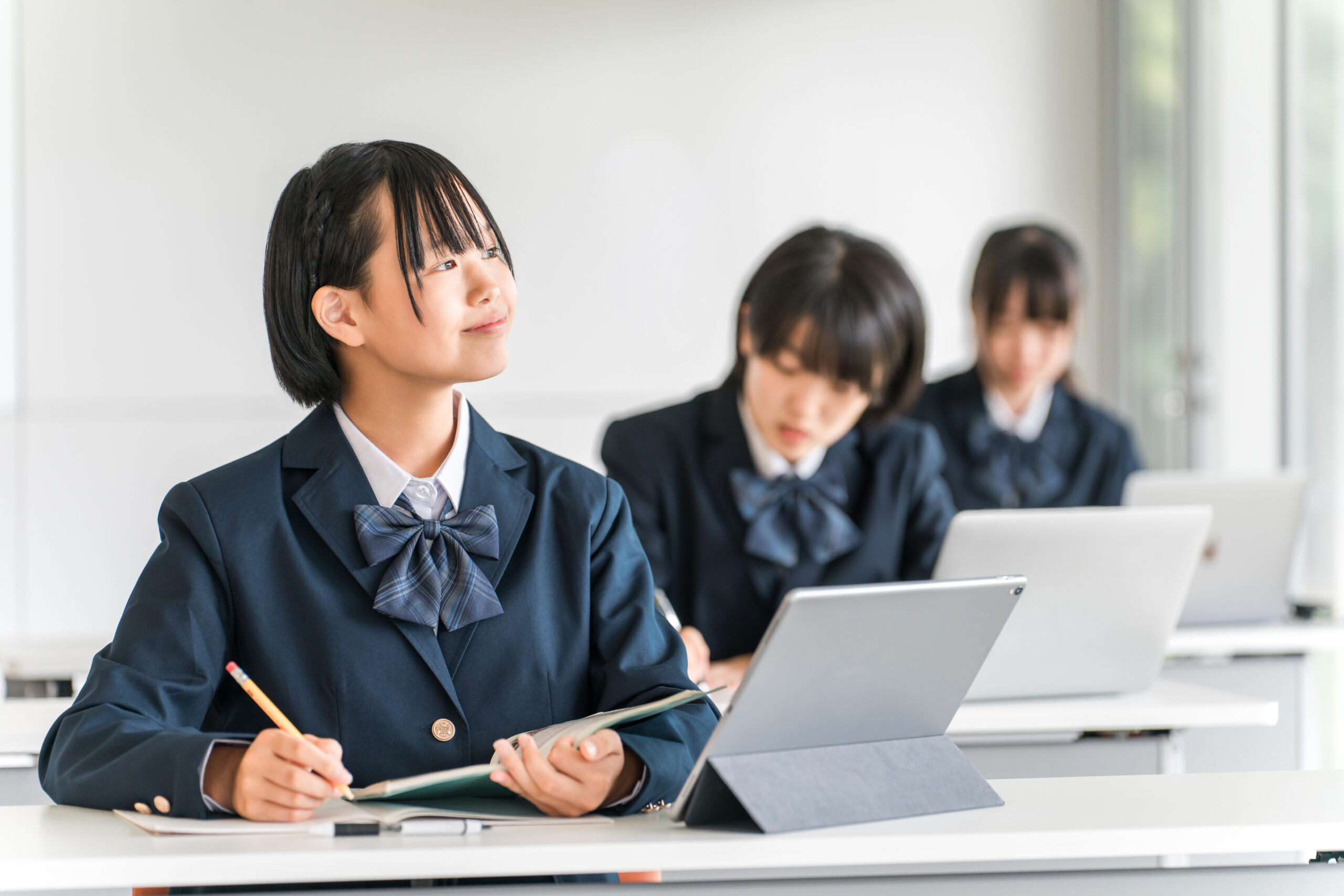 進路や受験勉強の悩みを抱えながら窓の外を見つめる女子中学生